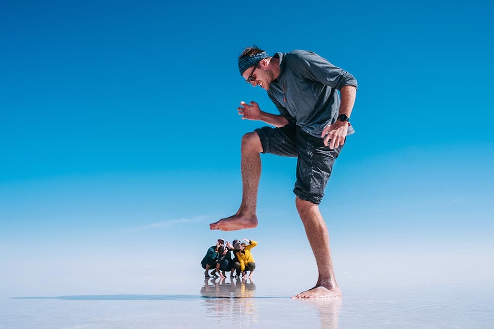 Fun forced perspective shot of young tourists at Uyuni Salt Flats (Spanish: Salar de Uyuni ) in Bolivia, South America.