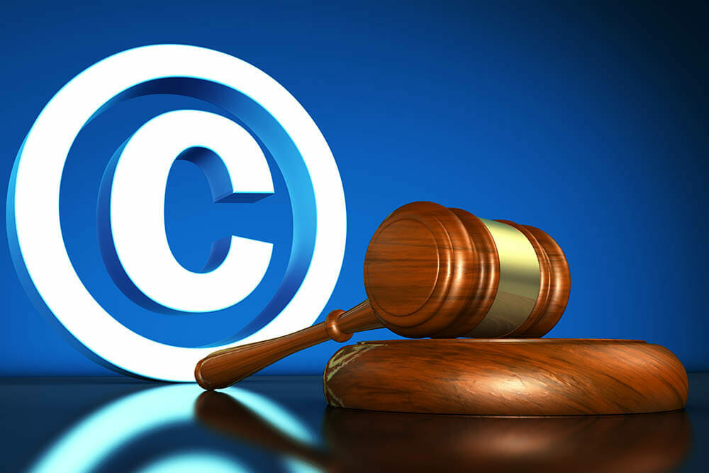 Intellectual property and digital copyright laws conceptual illustration with copyright symbol and icon and a gavel on blue background.